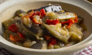 Berenjenas en escabeche, un plato casero con trozos de berenjena, pimientos rojos y cebolla en una salsa sabrosa.