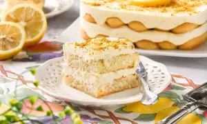 Delicioso tiramisú de limón, con capas de bizcocho, crema y soletillas, decorado con ralladura y rodajas de limón.