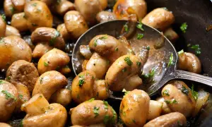 Champiñones dorados y jugosos, recién salidos de la freidora de aire, con perejil fresco picado. ¡Una delicia fácil y rápida!