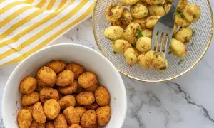 Dos boles llenos de ñoquis en freidora de aire, uno con especias y otro con perejil fresco. ¡Un aperitivo perfecto!
