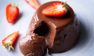 Delicioso flan de chocolate cremoso, decorado con fresas frescas. ¡Un postre irresistible!
