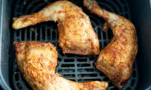 Muslos de pollo dorados y jugosos en la freidora de aire, listos para disfrutar.
