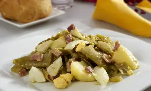 Deliciosa ensalada de judías verdes con trocitos de jamón y huevo duro, acompañada de patatas. Un plato casero y sabroso.