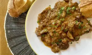 Delicioso fricando de ternera con trozos de pan crujiente, listo para disfrutar.
