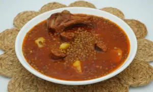 Un plato humeante de lentejas con chorizo, patatas y un muslo de pollo. Un manjar casero listo para disfrutar.