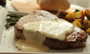 Tierna ternera en salsa cremosa, acompañada de espárragos y patatas asadas. Un plato principal delicioso.
