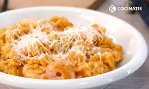 Un cremoso risotto de gambas, coronado con queso rallado, listo para disfrutar.