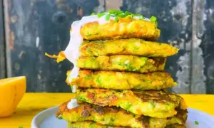 Torre de tortitas de brócoli y zanahoria, cubiertas con crema y cebollino.