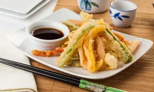 Crujiente tempura de verduras, con zanahoria, calabacín y pimiento, servida con salsa de soja.
