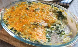 Delicioso plato de espinacas a la crema, gratinado con queso dorado y burbujeante, listo para servir.