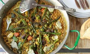 Un delicioso arroz con verduras, lleno de brócoli, espárragos y alcachofas, listo para servir.