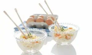 Delicioso arroz Nelba preparado en Thermomix, servido en cuencos de cristal con palillos y huevos de fondo.