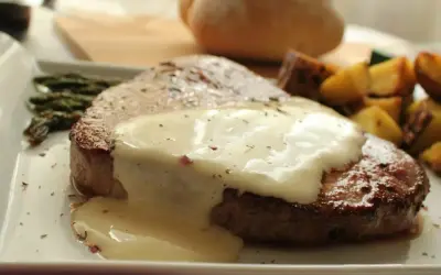 Tierna ternera en salsa cremosa, acompañada de espárragos y patatas asadas. Un plato principal delicioso.