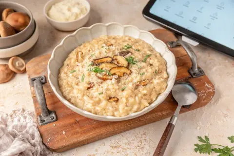 Delicioso risotto de setas hecho en Thermomix, servido en un cuenco blanco con láminas de shiitake y perejil fresco.
