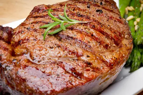 Jugoso filete de ternera a la parrilla con romero y espárragos verdes.