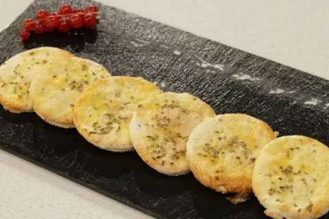 Deliciosas tortas de anís, doradas y crujientes, adornadas con semillas de anís y un toque de frutos rojos.