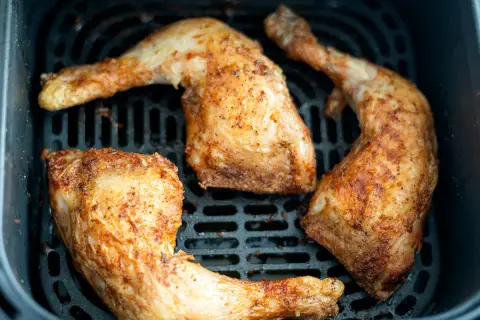 Muslos de pollo dorados y jugosos en la freidora de aire, listos para disfrutar.