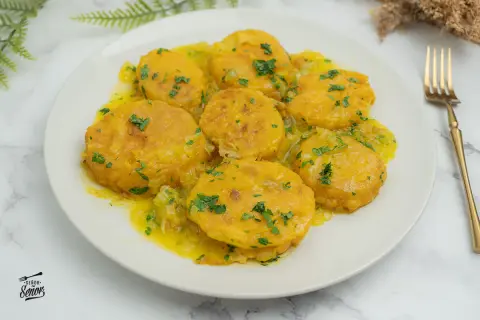 Patatas a la importancia, doradas y tiernas, bañadas en una salsa amarilla con perejil picado. Un plato que demuestra la importancia de las patatas en la cocina.