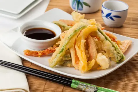Crujiente tempura de verduras, con zanahoria, calabacín y pimiento, servida con salsa de soja.