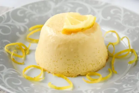 Delicioso flan de limón, con un toque cítrico y decorado con cáscara de limón.