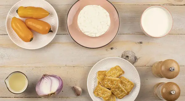 Ingredientes para papa a la huancaina: ajíes amarillos, queso fresco, leche, galletas, cebolla, ajo y aceite.