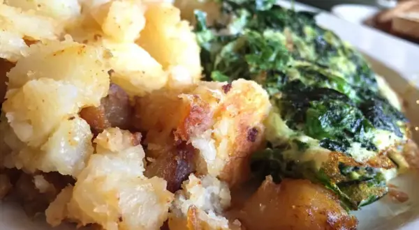 Patatas doradas y crujientes junto a unas espinacas con patatas, un plato casero y reconfortante.