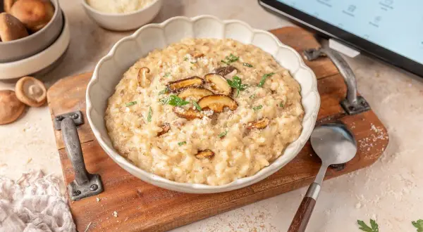 Delicioso risotto de setas hecho en Thermomix, servido en un cuenco blanco con láminas de shiitake y perejil fresco.