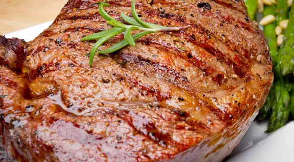 Jugoso filete de ternera a la parrilla con romero y espárragos verdes.