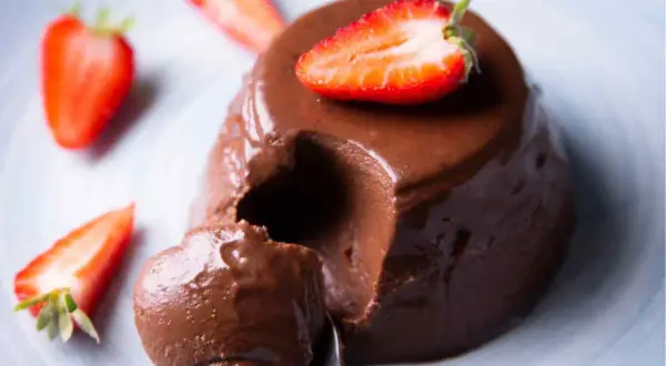 Delicioso flan de chocolate cremoso, decorado con fresas frescas. ¡Un postre irresistible!