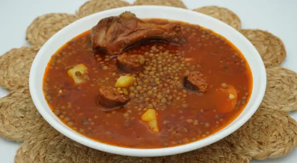 Un plato humeante de lentejas con chorizo, patatas y un muslo de pollo. Un manjar casero listo para disfrutar.