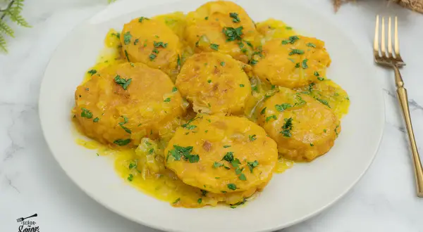 Patatas a la importancia, doradas y tiernas, bañadas en una salsa amarilla con perejil picado. Un plato que demuestra la importancia de las patatas en la cocina.