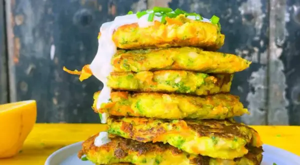 Torre de tortitas de brócoli y zanahoria, cubiertas con crema y cebollino.