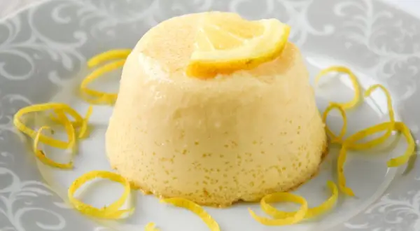 Delicioso flan de limón, con un toque cítrico y decorado con cáscara de limón.