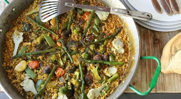 Un delicioso arroz con verduras, lleno de brócoli, espárragos y alcachofas, listo para servir.