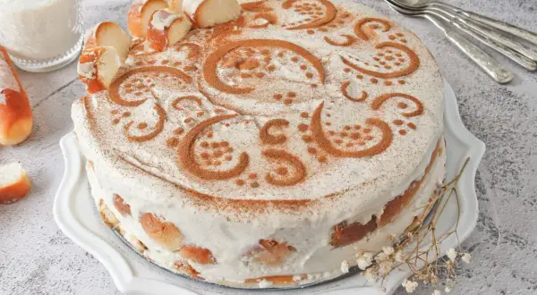 Tarta de horchata y fartons, decorada con canela y trozos de pan. Un postre que evoca la tradición valenciana.