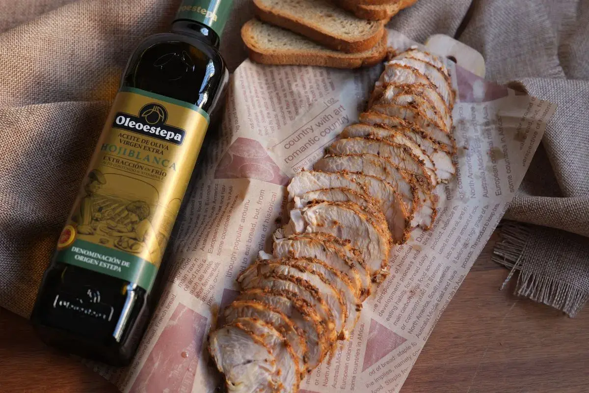 Fiambre de pavo casero, jugoso y tierno, acompañado de tostadas y aceite de oliva virgen extra Oleoestepa.