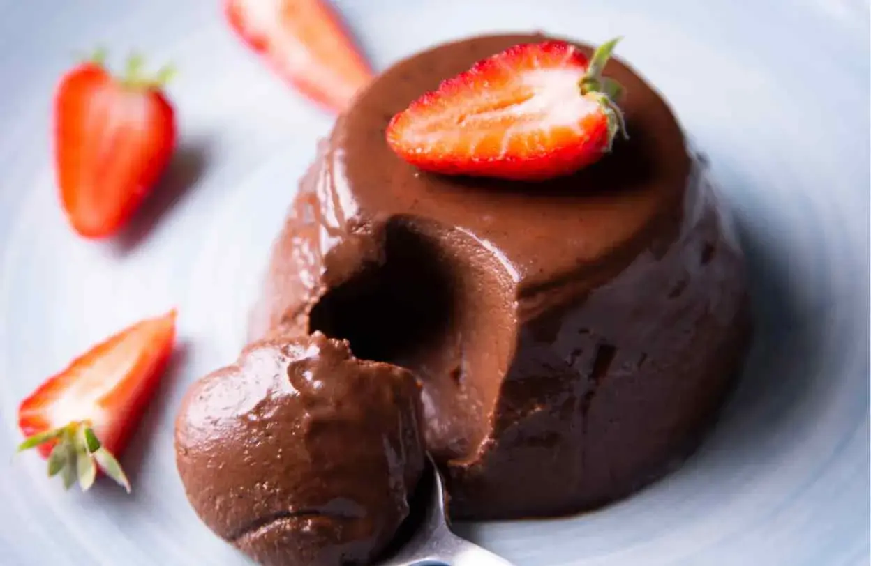 Delicioso flan de chocolate cremoso, decorado con fresas frescas. ¡Un postre irresistible!