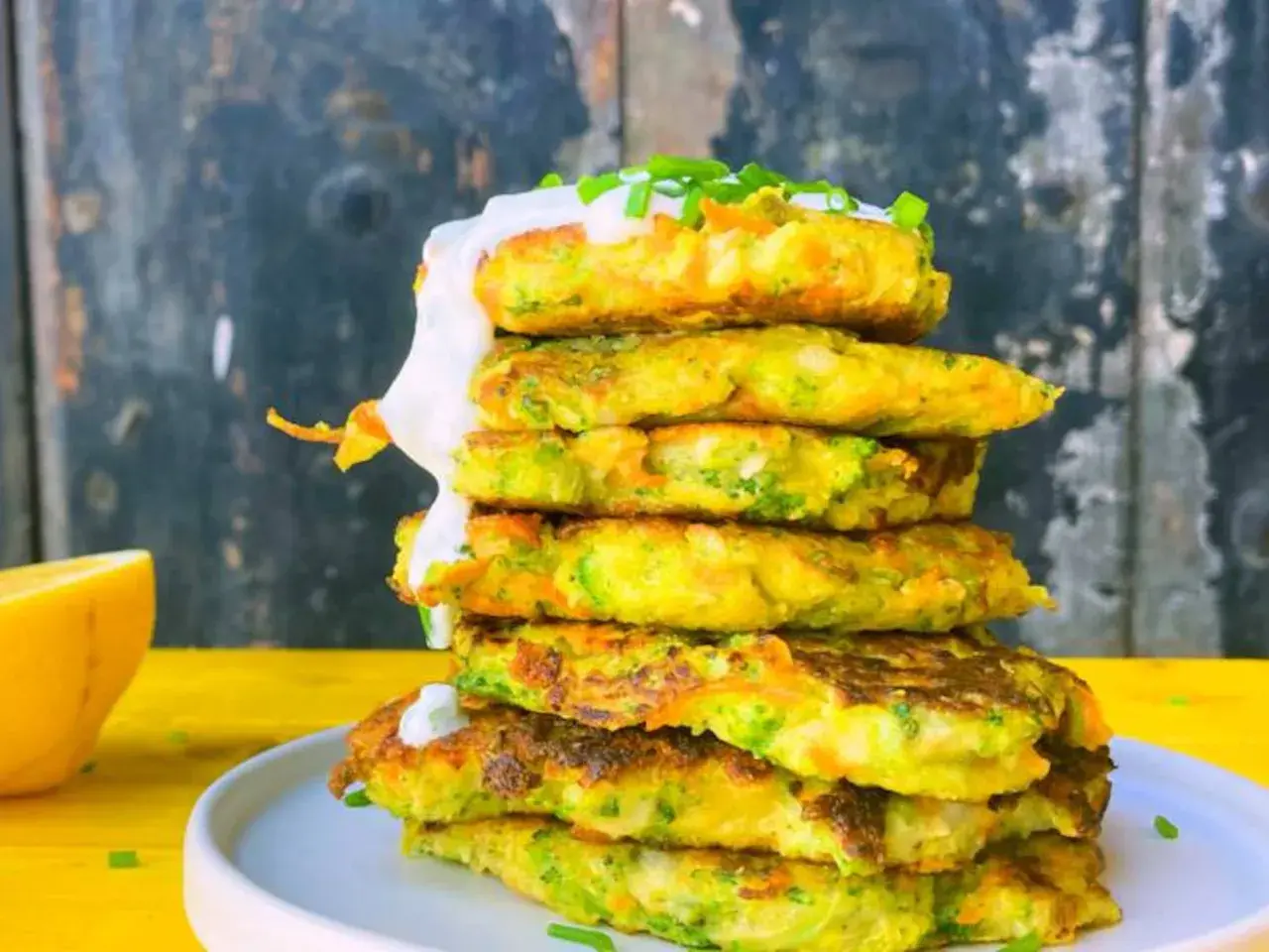 Torre de tortitas de brócoli y zanahoria, cubiertas con crema y cebollino.