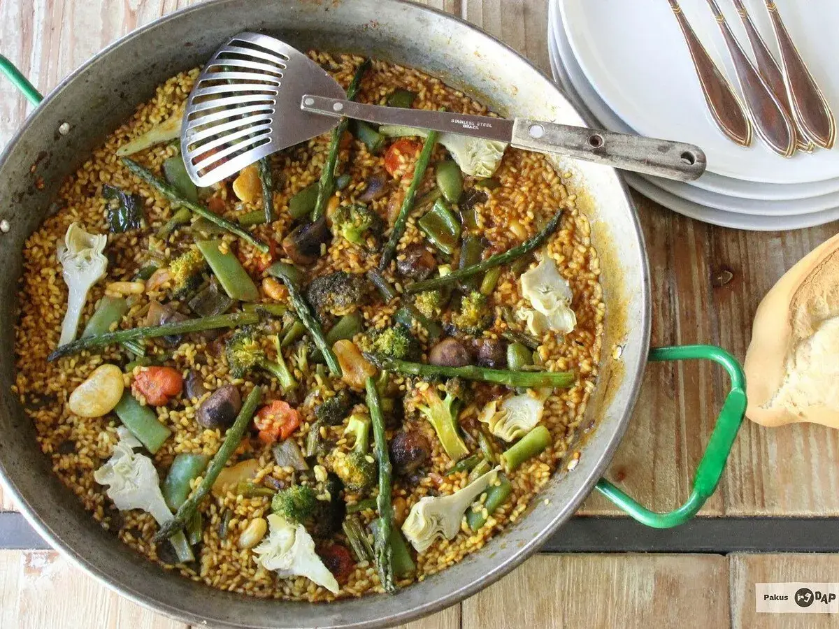 Un delicioso arroz con verduras, lleno de brócoli, espárragos y alcachofas, listo para servir.