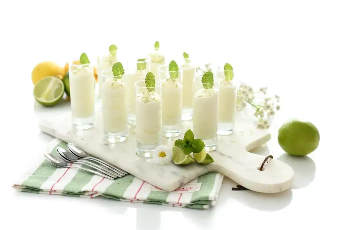 Delicioso mousse de limón Thermomix en vasitos, decorado con menta y ralladura de limón. Frescura y sabor en cada bocado.