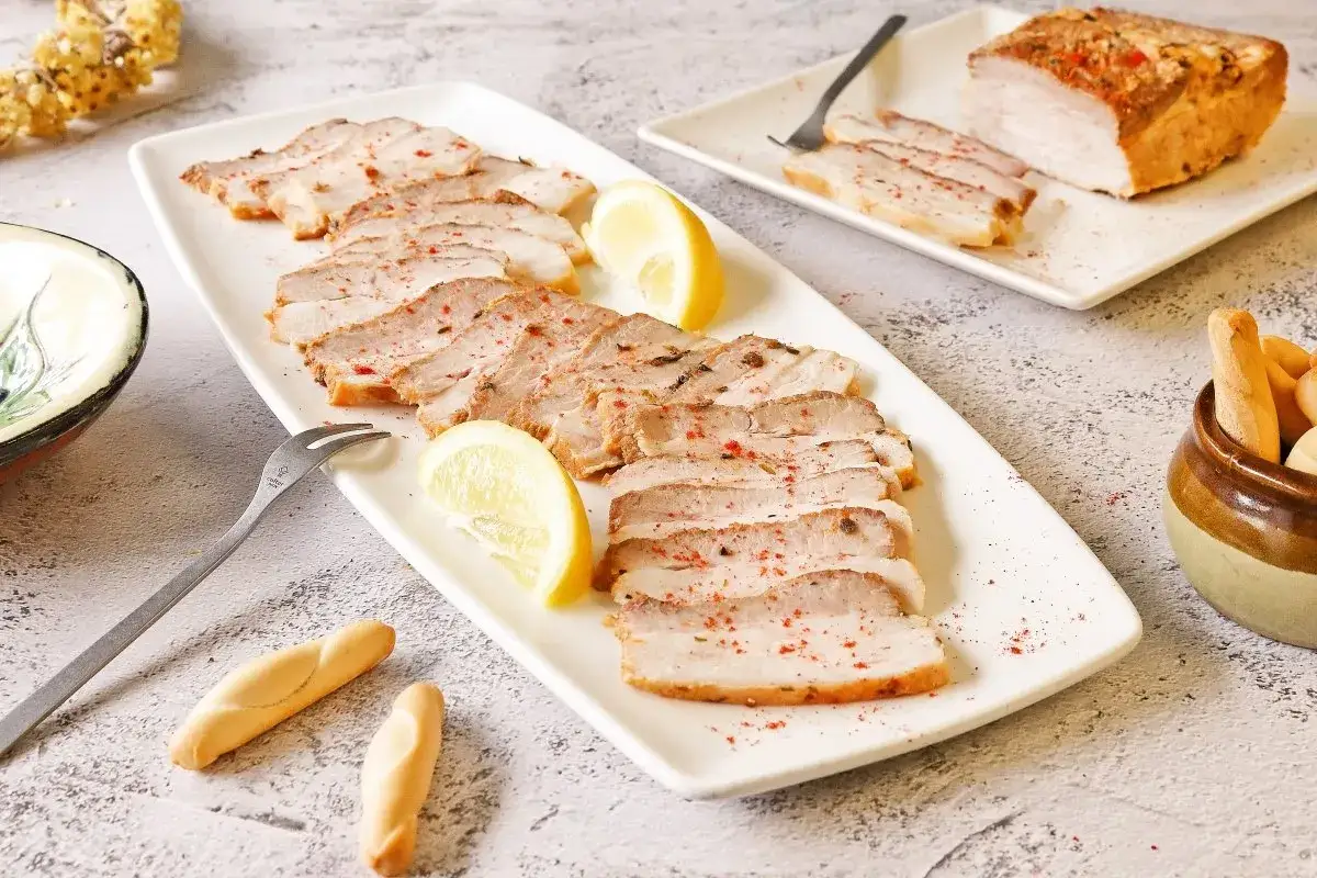Chicharr&oacute;n de C&aacute;diz en lonchas, servido con lim&oacute;n y picos. Un plato que evoca la tradici&oacute;n gaditana.