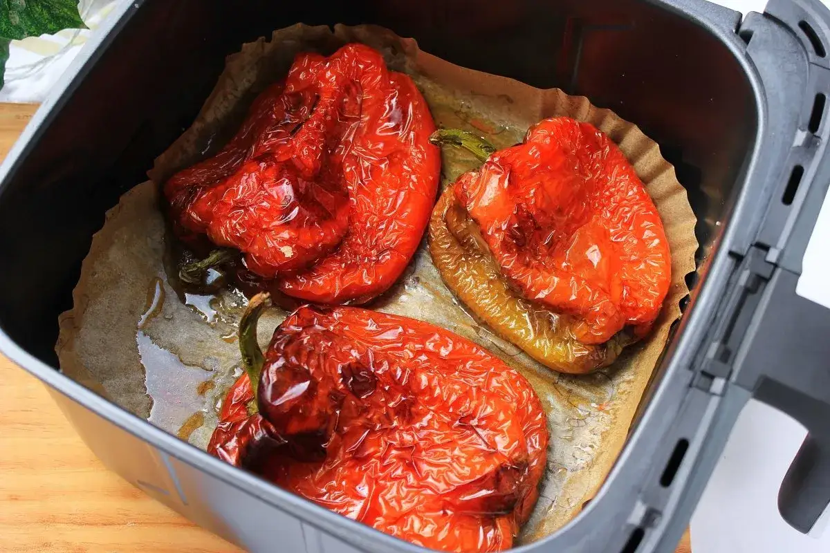 Pimientos rojos asados en freidora de aire, con la piel arrugada y jugosos, listos para disfrutar.