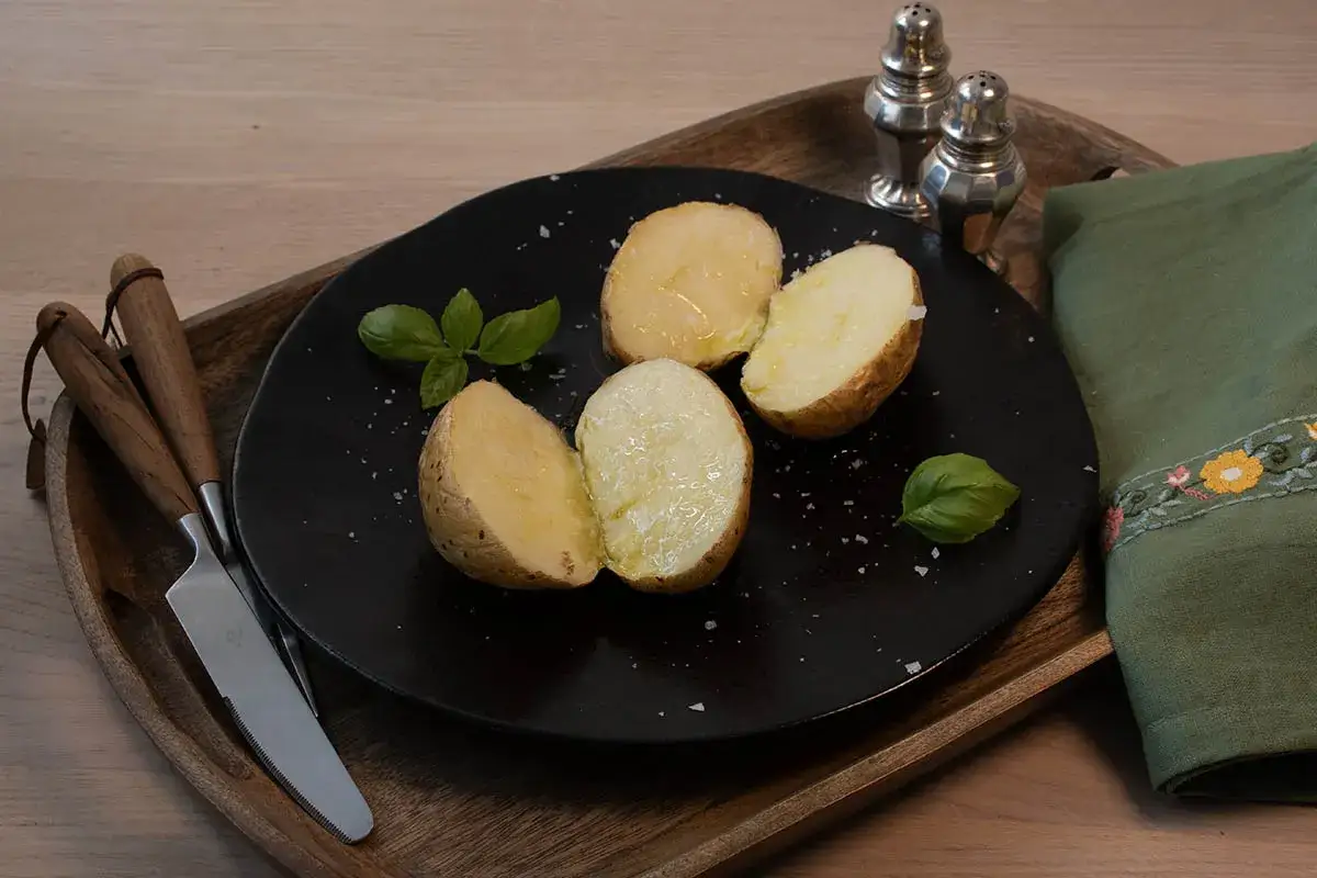 Patatas al microondas, tiernas y doradas, servidas con albahaca fresca y sal gruesa. Un plato sencillo y delicioso.