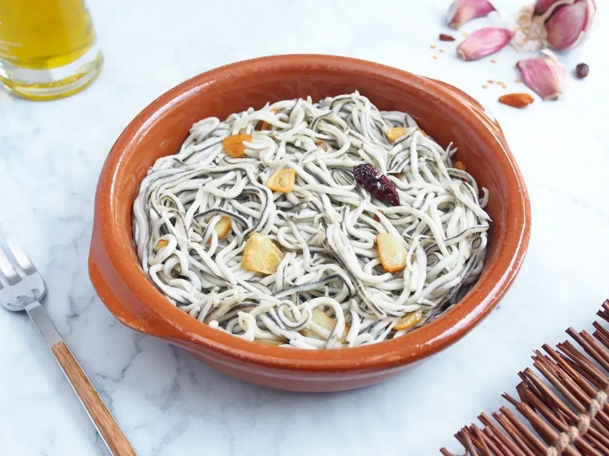 Deliciosas gulas al ajillo en cazuela de barro, con l&aacute;minas de ajo dorado y un toque picante.