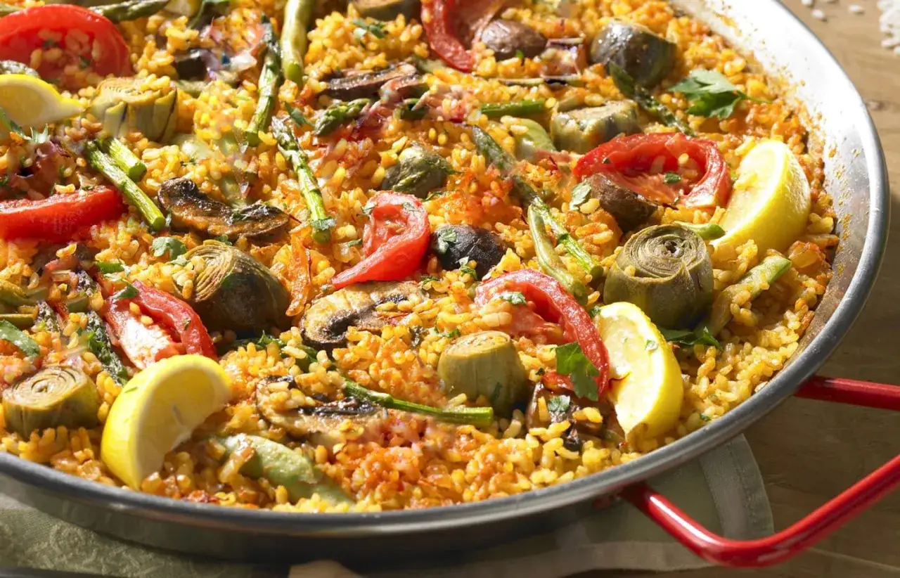 Un delicioso arroz con verduras en paellera, con alcachofas, esp&aacute;rragos, tomate y lim&oacute;n.