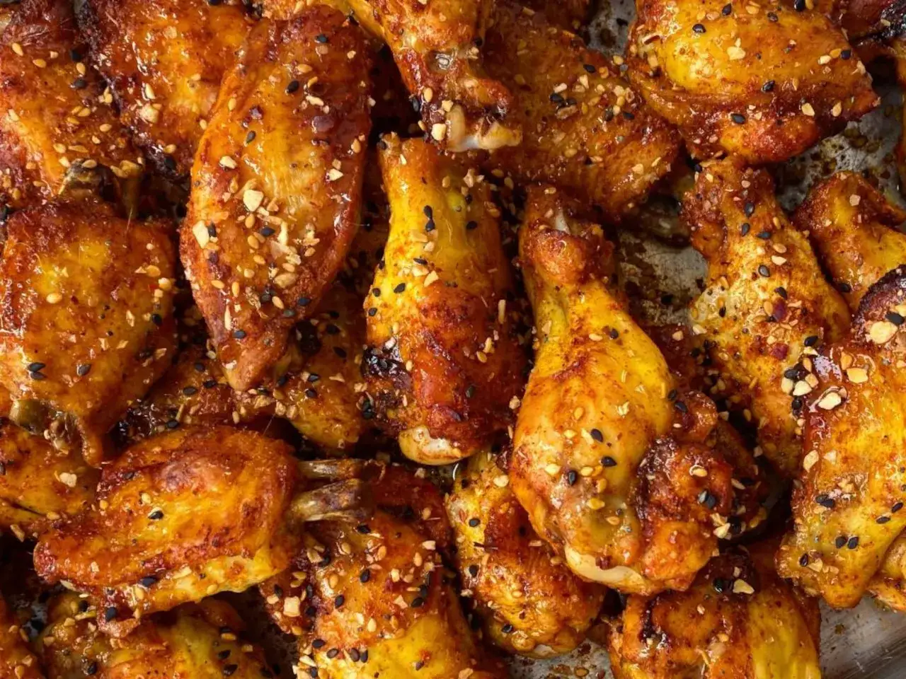 Alitas de pollo al horno crujientes, doradas y cubiertas con semillas y especias. &iexcl;Un fest&iacute;n para la vista y el paladar!