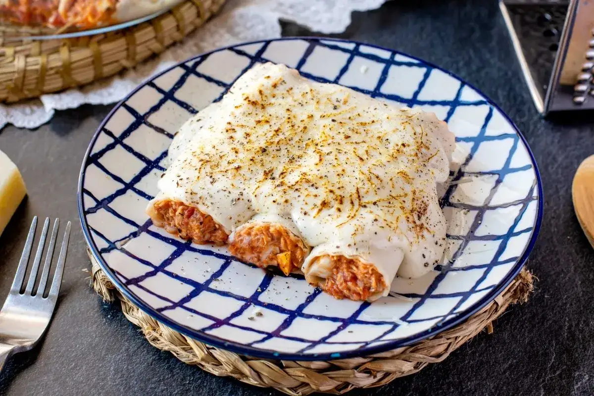 Canelones de at&uacute;n gratinados, cubiertos de bechamel y queso, listos para disfrutar.