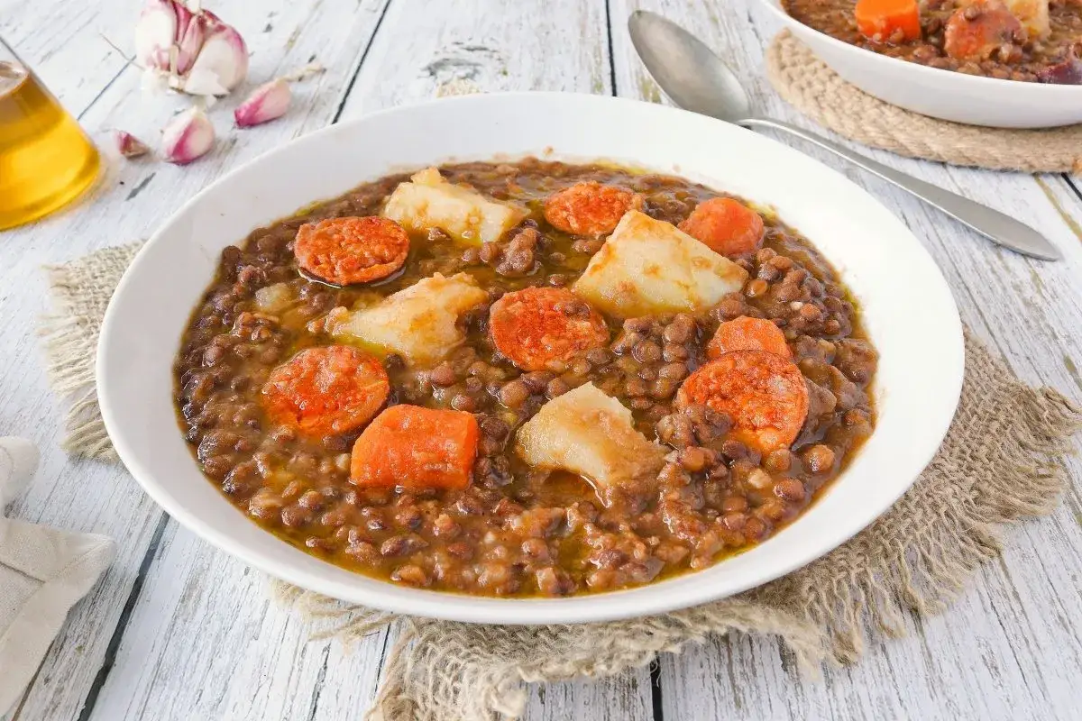 Un plato humeante de lentejas con chorizo, patatas y zanahoria, listo para disfrutar.