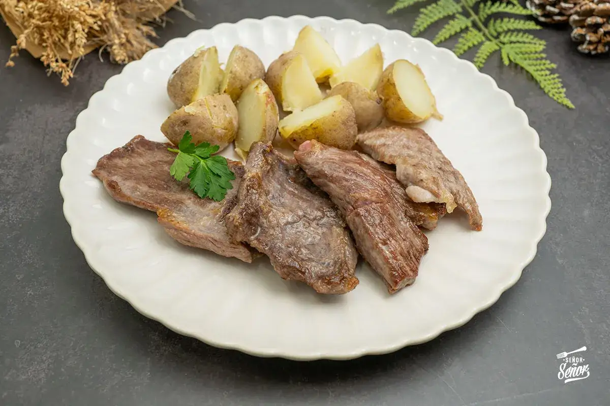 El secreto ibérico, jugoso y tierno, acompañado de patatas asadas y perejil fresco. Un manjar para descubrir.
