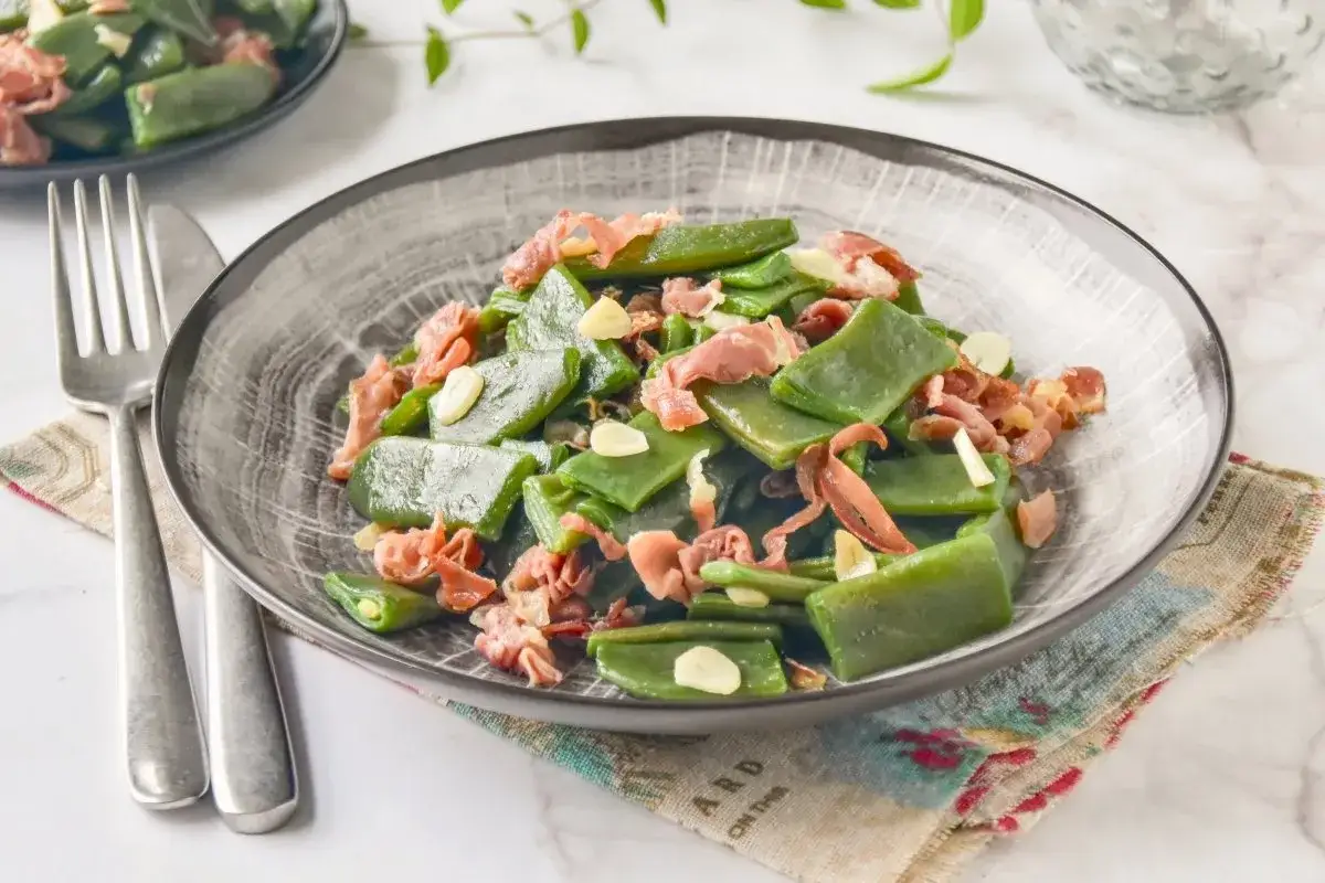 Plato de judías verdes con jamón serrano y láminas de ajo. Un clásico sencillo y delicioso.